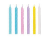 Six tall spiral candles in pastel colors including light blue, pink, purple, yellow, and white arranged in a row.