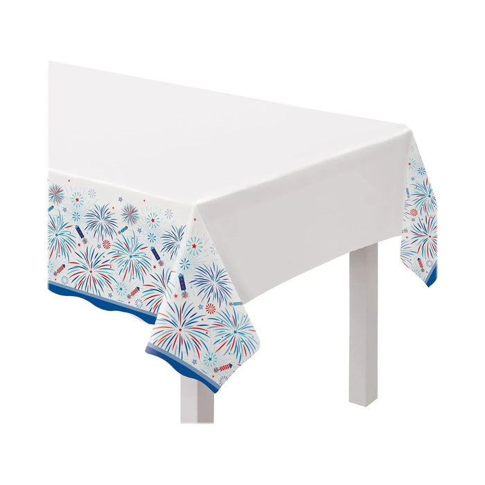 White rectangular tablecloth with red, white, and blue fireworks pattern and blue trim border, displayed on a white table.