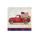Red vintage truck with USA text carrying American flag and patriotic bunting on cream napkin with confetti and navy star border.