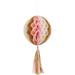 Spherical honeycomb paper decoration in pink, cream, and gold with matching tassel hanging below.