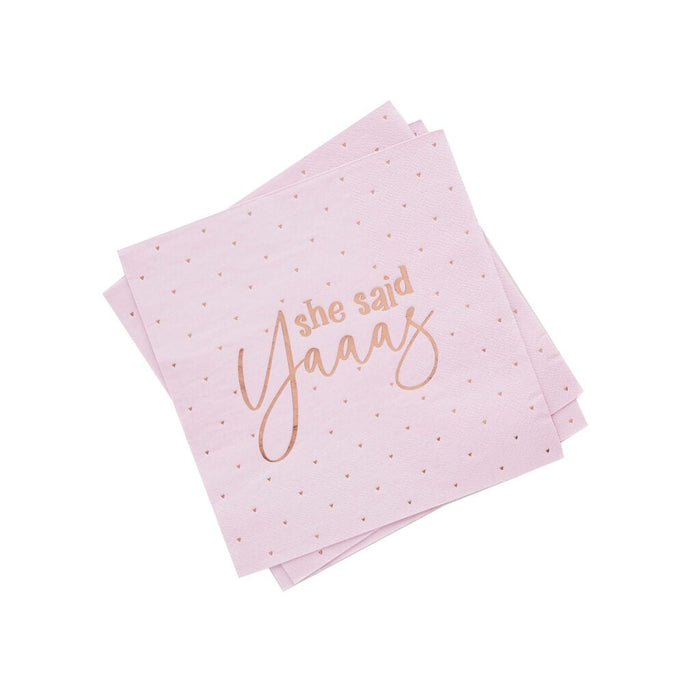 Stack of pink napkins with small red hearts scattered throughout and rose gold text reading "she said Yaaas" printed on the front.