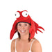 Bright red plush crab hat with oversized white and black eyes, red claw-shaped ear flaps, and a wide smiling mouth, worn by a smiling woman against a white background.