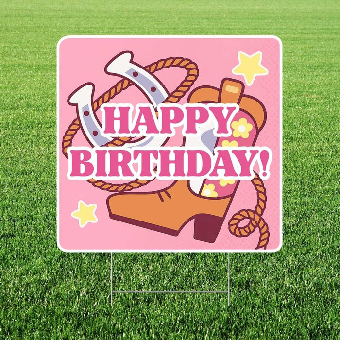 Pink yard sign with white border featuring cowboy boots, horseshoes, ropes, yellow stars, and bold magenta text reading "HAPPY BIRTHDAY!