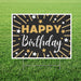 Black and gold yard sign with "Happy Birthday" text, radiating gold and white stars, and supporting stakes, displayed on grass.