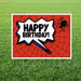 Red spider web patterned yard sign with white speech bubble containing bold black "HAPPY BIRTHDAY!" text, blue lightning bolt accent, and black spider silhouette in upper right corner.