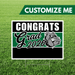 Graduation-themed sign with 'Congrats Grad 2026' on a grass background