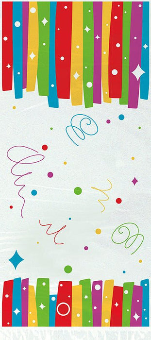 Colorful cellophane treat bags with rainbow vertical stripes, stars, and dots, arranged in a flat lay with decorative swirls and scattered confetti elements between top and bottom rows.