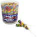 Clear plastic container filled with approximately 30 rainbow-striped spiral lollipops in red, yellow, green, and blue, with one lollipop displayed separately in front.