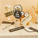Retirement party photo booth props set with ten black and cream decorative signs on sticks, including champagne glasses, caution tape, clocks, and humorous messages like "No Work Ahead" and "Retired Not Expired" arranged on a beige surface with wheat decorations.