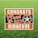 Orange and black yard sign with white text reading "Congrats Grad 2026 Ridgevue" and a silver star logo, displayed on grass.