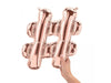 Rose gold foil hashtag symbol balloon being held by a hand against a white background.