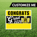 Graduation-themed sign with 'Congrats Grad 2026' on a grass background