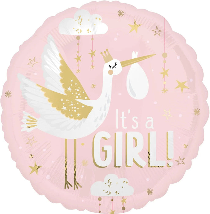 Pink round mylar balloon featuring a white stork with gold wings carrying a baby bundle, surrounded by gold stars and clouds, with "It's a girl" text in white and gold lettering.