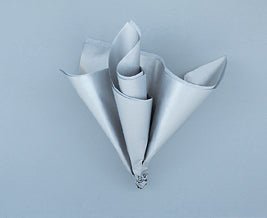 Five rolled sheets of silver metallic tissue paper arranged in a bouquet formation against a light blue background.