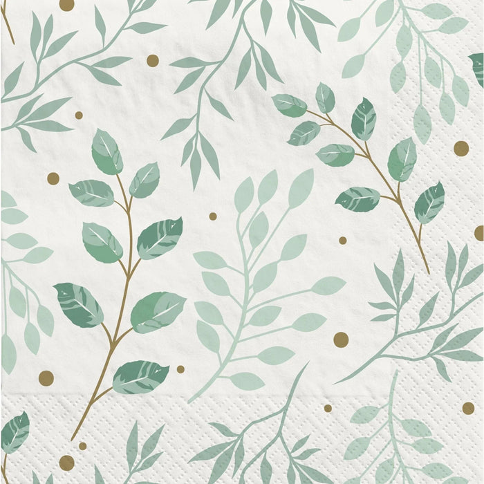 White paper napkins featuring green leafy botanical branches and small gold dots scattered throughout in a delicate repeating pattern.