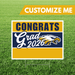 Graduation-themed sign with 'Congrats Grad 2026' and an eagle logo on a grass background.