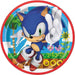 Round paper plate with red border featuring Sonic the Hedgehog in blue with white gloves, peachy ears, and red shoes, waving against a sunny green landscape background.