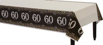 Black and gold sparkly plastic tablecover with repeated white "60" numerals across the border and cream-colored center panel.