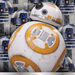 White and orange spherical droid with blue dome head displayed against blue and white patterned background featuring matching droid designs.