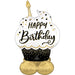 White cupcake-shaped foil balloon with black and gold confetti design, gold candle on top, "Happy Birthday" text in black and gold, black base with gold dots, and gold balloon base.