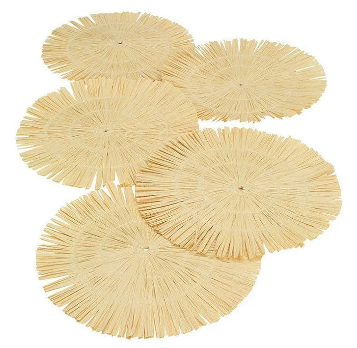 Set of five natural woven straw placemats with fringe edges arranged in an overlapping display on a white background.