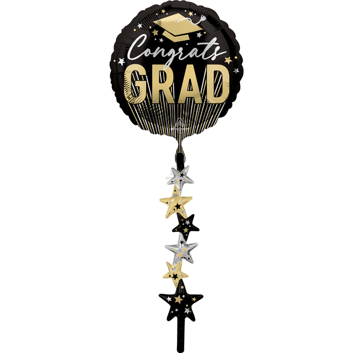 Black and gold "Congrats Grad" round foil balloon with decorative stars and a mortarboard cap, featuring a cascading strand of alternating gold, silver, and black star charms.