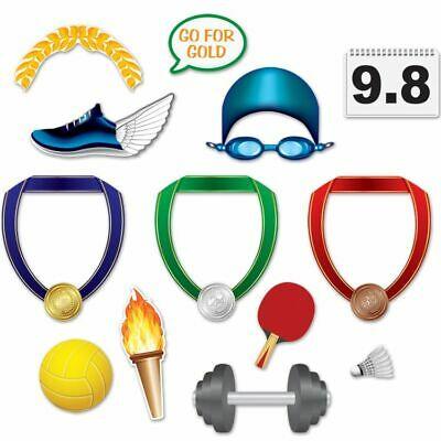 Collection of 13 colorful sports and Olympic-themed photo props including gold, silver, and bronze medals on colored ribbons, winged shoe, swimming goggles, torch, volleyball, ping pong paddle, badminton shuttlecock, dumbbell, laurel wreath, and a 9.8 score card.