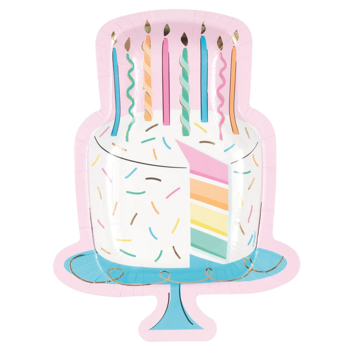 Colorful birthday cake shaped paper plates featuring a white frosted cake design with rainbow layer detail, pastel candles on top, and a blue cake stand base.