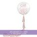 Clear bubble balloon with pink "Sweet Sixteen" script text and confetti inside, featuring two pink ribbon tassel tails, helium not included.