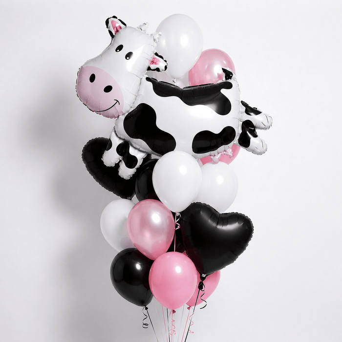 Adorable balloon bouquet featuring a large cartoon cow foil balloon, surrounded by pink, white, and black latex and two black heart shaped foil balloons.