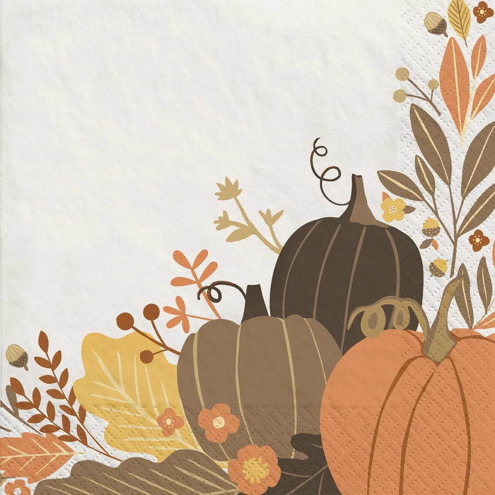 Decorative paper napkin featuring autumn pumpkins in orange, brown, and gold with fall foliage and seasonal flowers in earth tones.