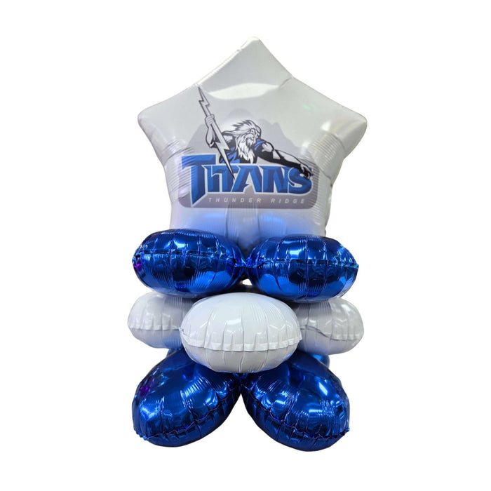 Stacked arrangement of four metallic blue foil balloons and one white foil balloon topped with a white t-shirt featuring the Titans Thunder Ridge logo in blue.