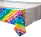 Colorful tie-dye plastic tablecloth with diagonal stripes in rainbow colors including blue, green, yellow, red, and purple, displayed draped over a white surface.