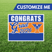 Graduation-themed sign with 'Congrats Grad 2026' on a grass background