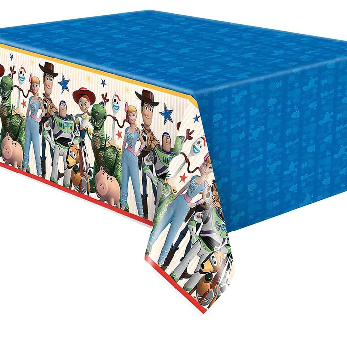Blue rectangular plastic tablecloth featuring Toy Story characters including Woody, Buzz Lightyear, and other cast members on a white and cream border with red trim.