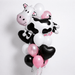 Cow-themed balloon bouquet featuring a large black-and-white cow-shaped foil balloon, black heart-shaped foil balloons, and black, white, and pink latex balloons with curling ribbons.