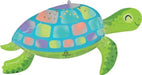 Colorful inflatable turtle balloon with a turquoise shell featuring multicolored squares, bright green flippers and head with closed eye design, and an Anagram brand mark visible on the shell.