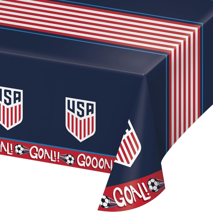 Dark blue plastic tablecloth with red and white striped border, USA soccer shield logos, and "GOAL" text with soccer balls printed along the edges.