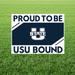 White and navy blue rectangular yard sign with "PROUD TO BE" at top, Utah State University logo in center, and "USU BOUND" at bottom, displayed in grass.