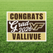 Rectangular yard sign with gold and brown horizontal stripes displaying "CONGRATS Grad 2026 VF VALLIVUE" in white and brown text, staked in green grass.
