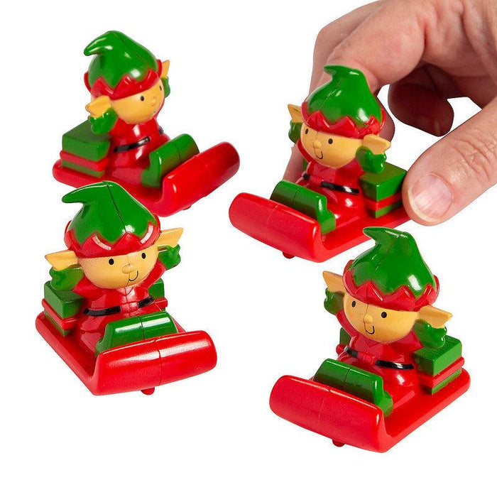 A group of Christmas Whimsical Elf Pull-Back Sleighs with a persons hand grabbing one to show scale.