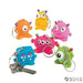 Six colorful vinyl monster keychains in orange, yellow, pink, red, blue, and green with googly eyes and horns arranged in a circle.