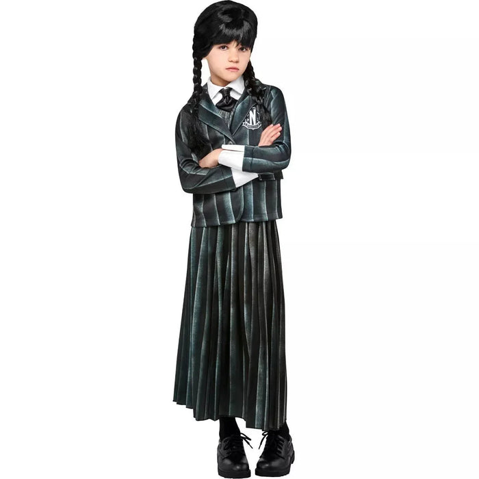 Child wearing a dark green plaid blazer with school crest, matching pleated skirt, white shirt, tie, black braids, and black platform boots.