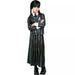 Child wearing a dark green plaid blazer with school crest, matching pleated skirt, white shirt, tie, black braids, and black platform boots.