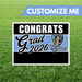 Graduation-themed customizable sign with 'Congrats Grad 2026' text on a grass background