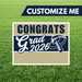 Graduation-themed sign with 'Congrats Grad 2026' on a grass background