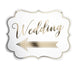 White decorative sign with scalloped edges featuring gold cursive text reading "Wedding" and a gold arrow banner on a white background.
