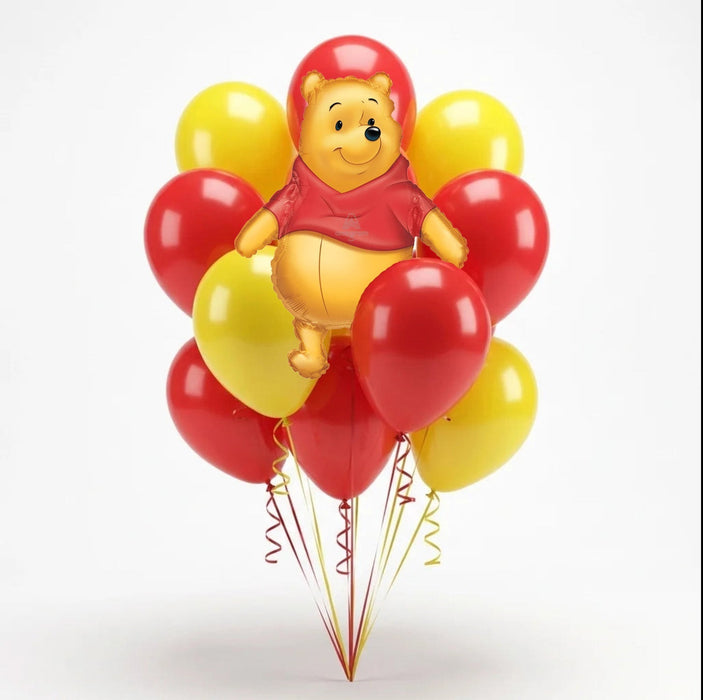 Winnie the Pooh character balloon centerpiece surrounded by red and yellow balloons with curled ribbons on a white background.
