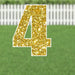 Gold glitter number 4 yard sign with white border and metal stakes, displayed on green grass with white picket fence background.