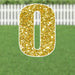 Gold glitter yard sign shaped like the number zero with a white border, displayed in grass with a white picket fence in the background.